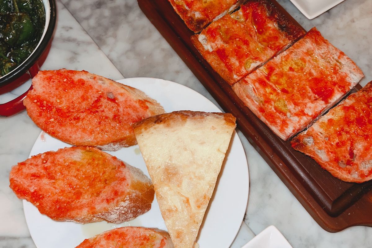 A spread of Catalan tapas with pa amb tomàquet on a bar counter