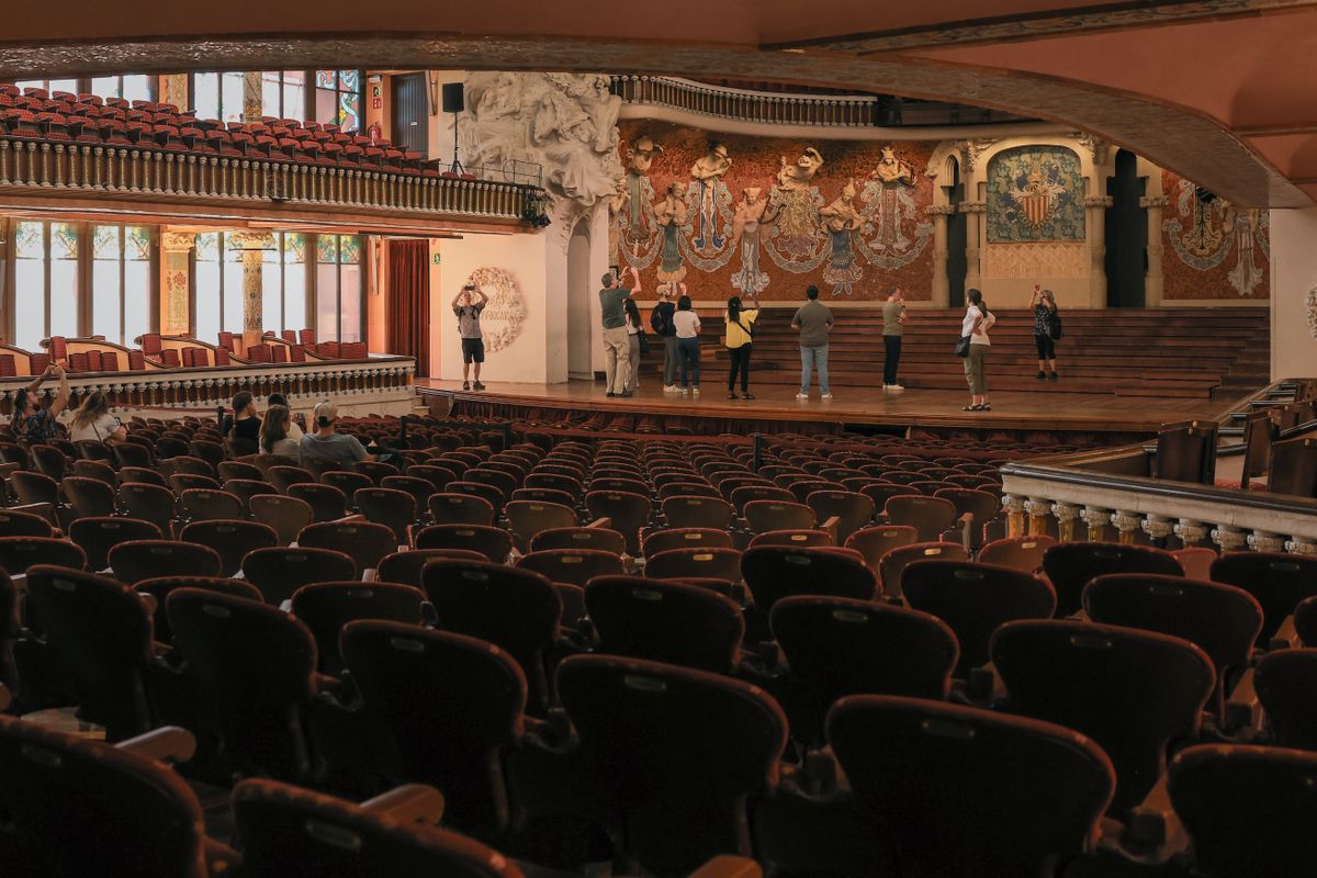 Ornate modernista concert hall interior of the Palau de la Música Catalana with sculpted stage and tiered seating
